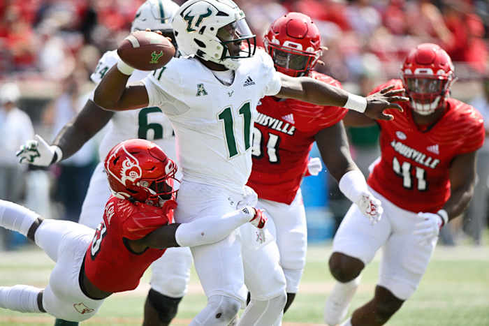 Sep 24, 2022; Louisville, Kentucky, USA; South Florida Bulls quarterback Gerry Bohanon (11) throws a pass under the pressure of Louisville Cardinals defensive back Kei'Trel Clark (13) during the second quarter at Cardinal Stadium. Mandatory Credit: Jamie Rhodes-USA TODAY Sports